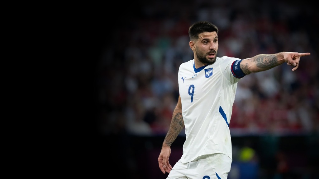 Aleksandar Mitrović u belom dresu reprezentacije Srbije pokazuje rukom smer napada